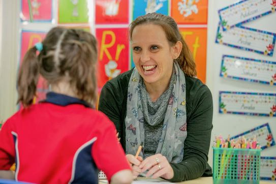 Teacher working one on one with a student in a classroom supporting personalised learning guidance and student engagement