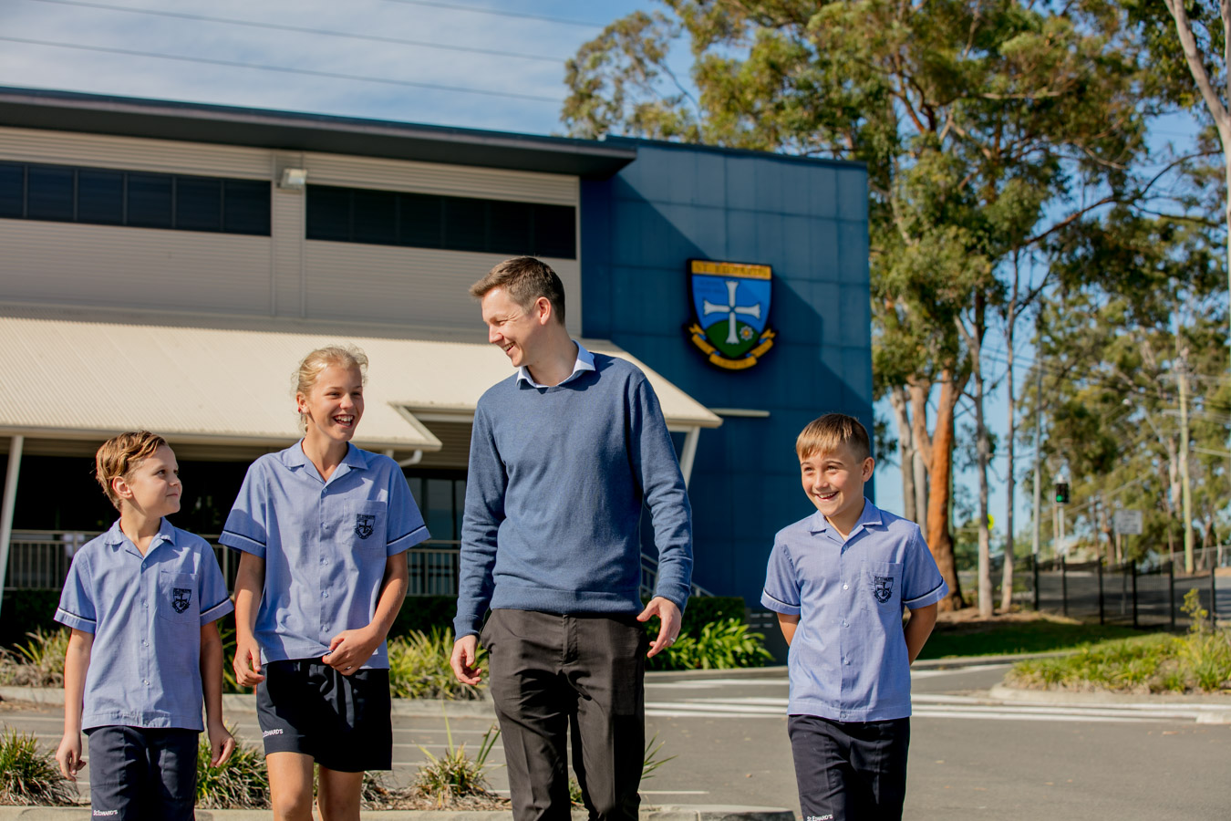 Student and staff member walking together across the school grounds at St Edward’s highlighting positive relationships guidance and a supportive school community