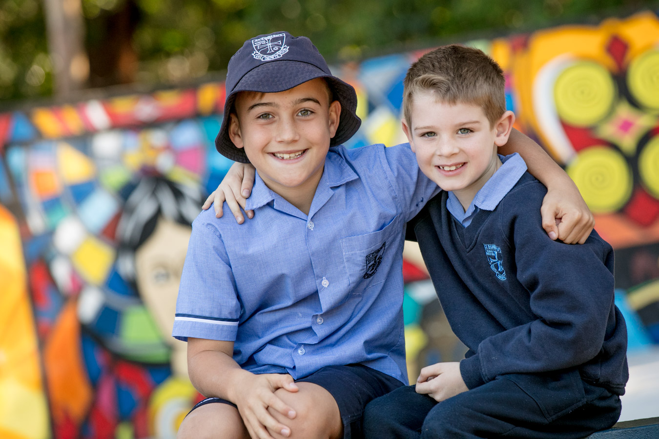 Students sitting together in school uniform with arms around each other highlighting friendship belonging and a supportive school community