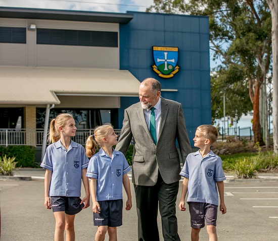 School principal walking with students outside the college highlighting leadership connection and a supportive school community