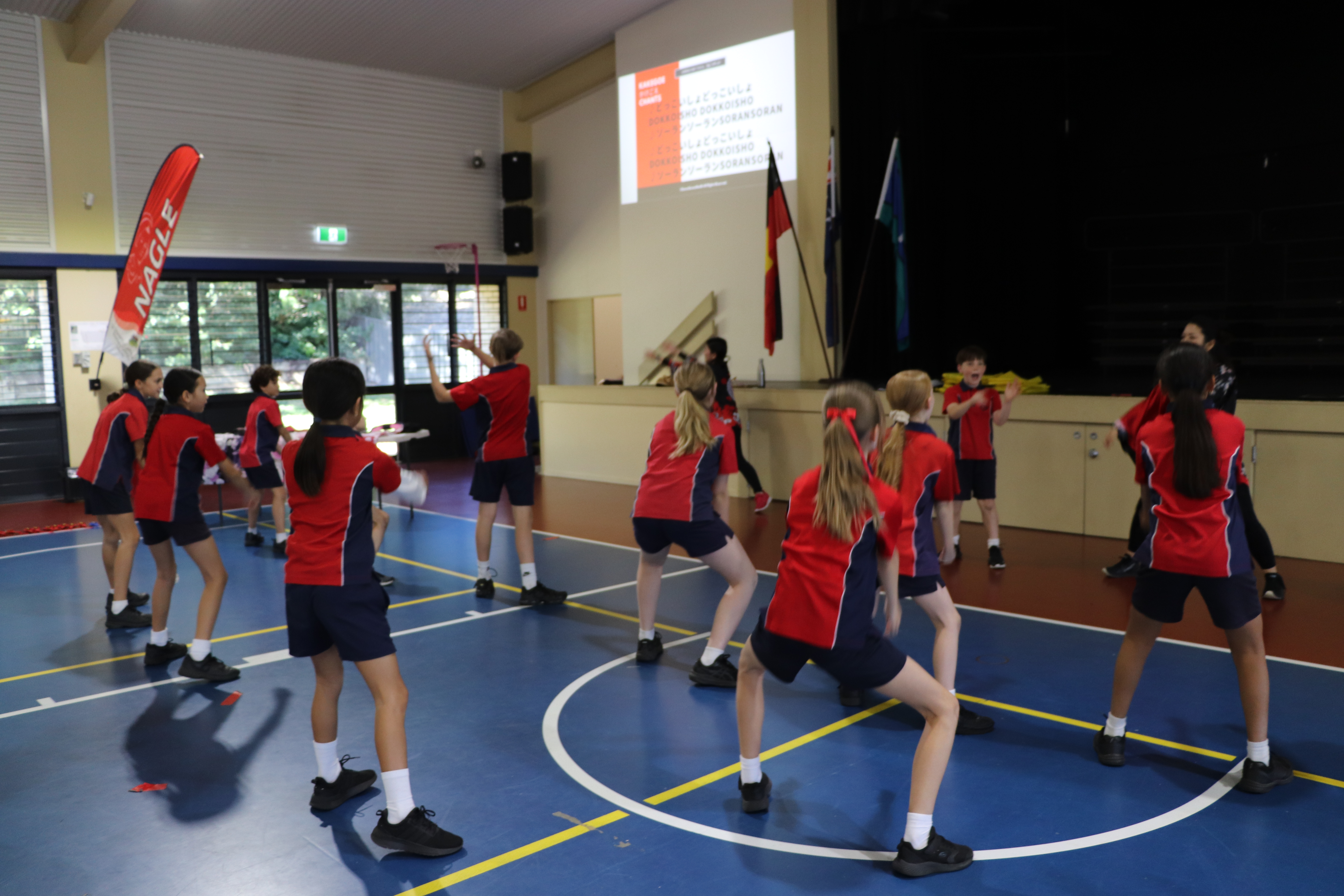 Students participating in an indoor group fitness or dance activity during a school session promoting teamwork physical activity and student engagement